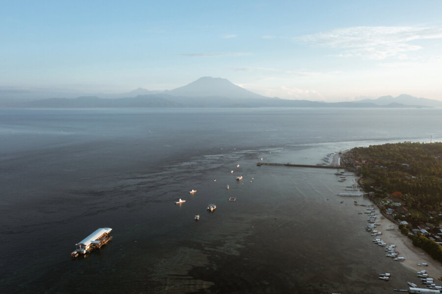 Drone shot from Adiwana Warnakali showing the pier and the volcano on the background, Nusa Penida