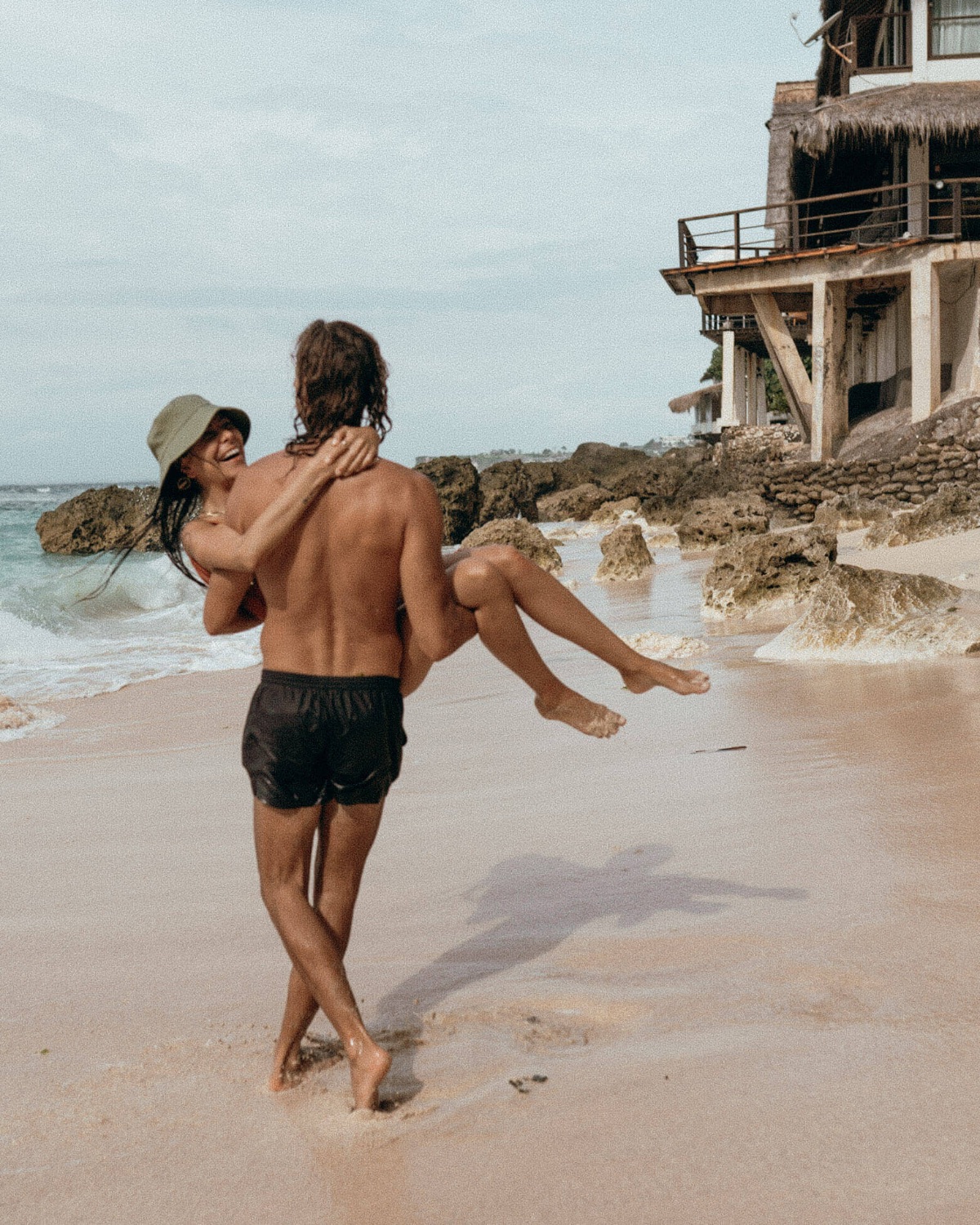 couple in the beach, man carrying woman in his arms