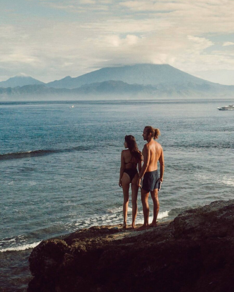 couple standing on the top of a mountain with volcano view