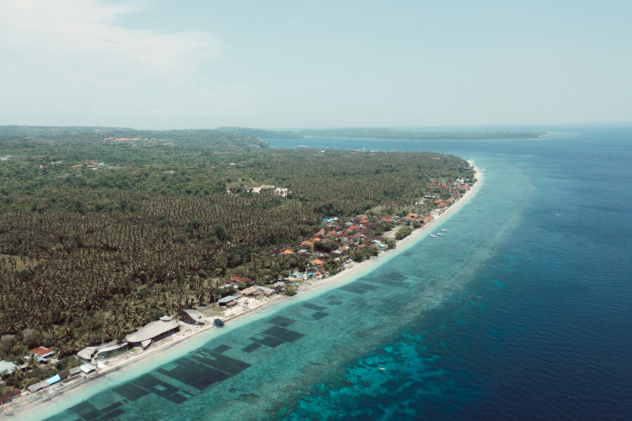 Drone shot from the north of toya pakeh, showing the beach and the nusas on the background, Nusa Penida